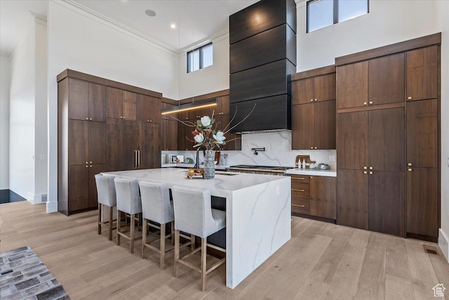 1316 N Gold Mountain Cir, Heber City, UT 84032 - kitchen featuring a sink, modern cabinets, a high ceiling, light wood finished floors, and a breakfast bar area