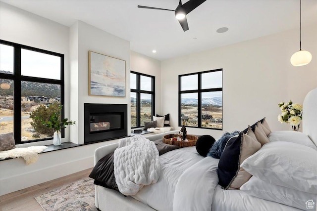 1316 N Gold Mountain Cir, Heber City, UT 84032 - bedroom featuring wood finished floors, a glass covered fireplace, a ceiling fan, and recessed lighting
