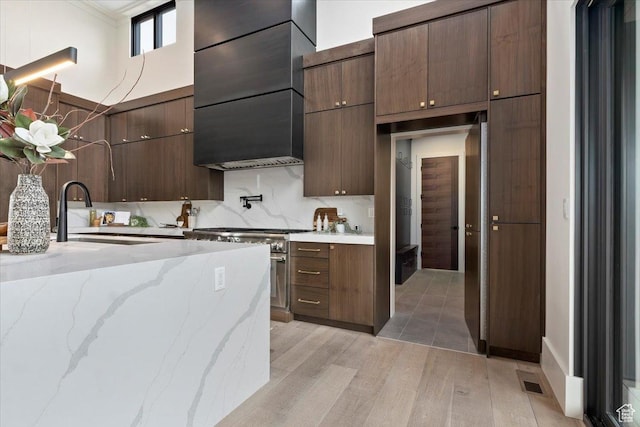 1316 N Gold Mountain Cir, Heber City, UT 84032 - kitchen featuring high end stainless steel range, light wood-type flooring, modern cabinets, open shelves, and wall chimney range hood