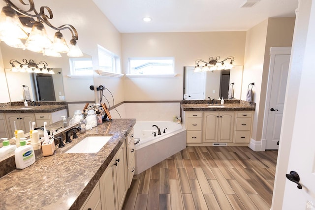 743 N 1100 E, Nephi, UT 84648 - bathroom featuring a chandelier, wood finished floors, a garden tub, and a sink