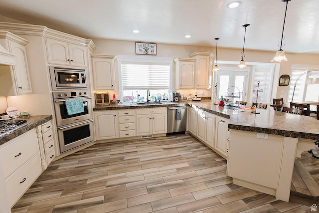 743 N 1100 E, Nephi, UT 84648 - kitchen with stainless steel appliances, a peninsula, a sink, a kitchen bar, and pendant lighting