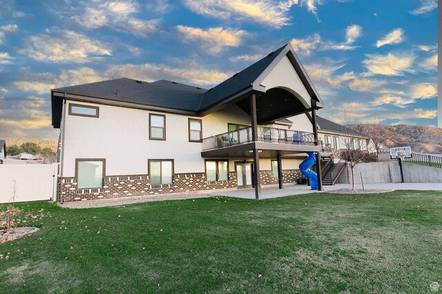 743 N 1100 E, Nephi, UT 84648 - back of house at dusk with a lawn, a patio, stucco siding, and fence