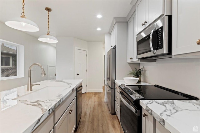 246 E 2100 S, South Salt Lake, UT 84115 - kitchen featuring stainless steel appliances, light wood-style flooring, hanging light fixtures, recessed lighting, and light stone counters