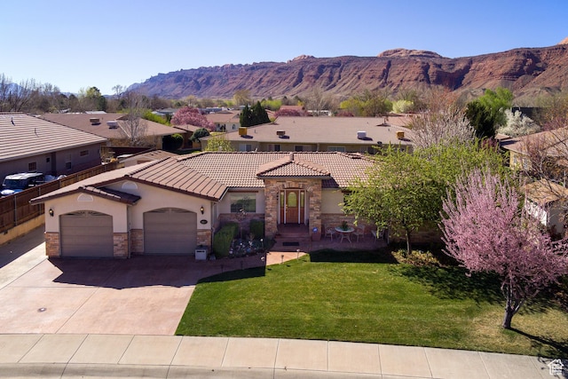 558 Winesap Cir, Moab, UT 84532 - mediterranean / spanish-style home with stucco siding, stone siding, driveway, a tile roof, and a garage