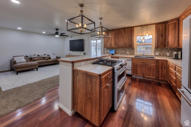 558 Winesap Cir, Moab, UT 84532 - kitchen featuring range with two ovens, a chandelier, dishwashing machine, dark wood finished floors, and brown cabinets