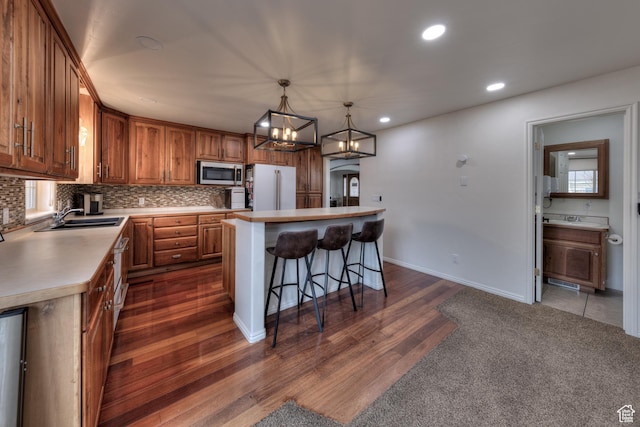 558 Winesap Cir, Moab, UT 84532 - kitchen with backsplash, sink, hanging light fixtures, a kitchen island, and white fridge