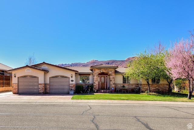 558 Winesap Cir, Moab, UT 84532 - mediterranean / spanish house with a garage, stone siding, stucco siding, concrete driveway, and a front lawn