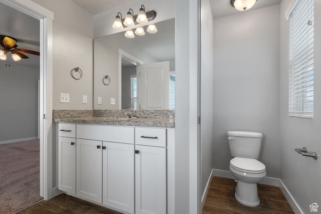 248 W Quartz Rd, Tooele, UT 84074 - bathroom featuring vanity, toilet, a ceiling fan, wood finished floors, and baseboards