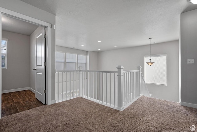 248 W Quartz Rd, Tooele, UT 84074 - hall with dark carpet, baseboards, and an upstairs landing