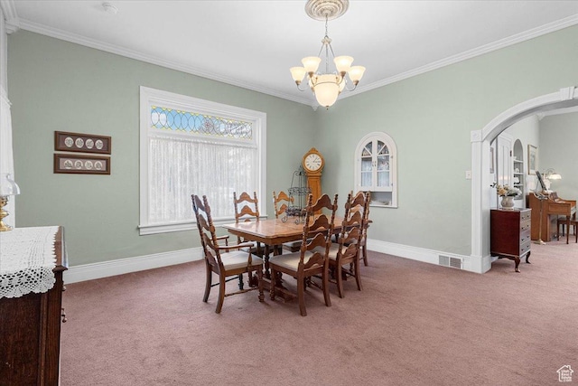 dining area with carpet flooring, ornamental molding, and an inviting chandelier