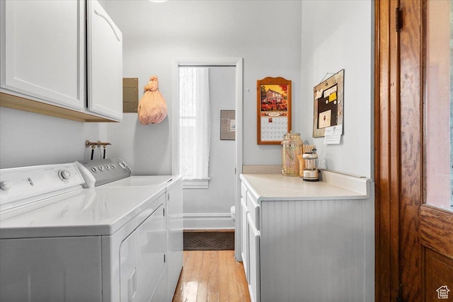 clothes washing area featuring cabinets, separate washer and dryer, and light hardwood / wood-style floors
