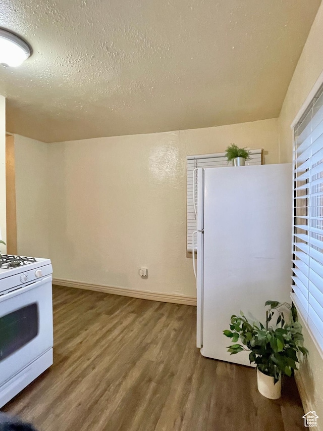 2433 Monroe Blvd, Ogden, UT 84401 - kitchen with a textured ceiling, white appliances, wood finished floors, and baseboards