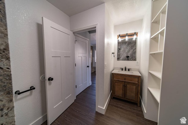 bathroom featuring built in shelves, vanity, and hardwood / wood-style flooring