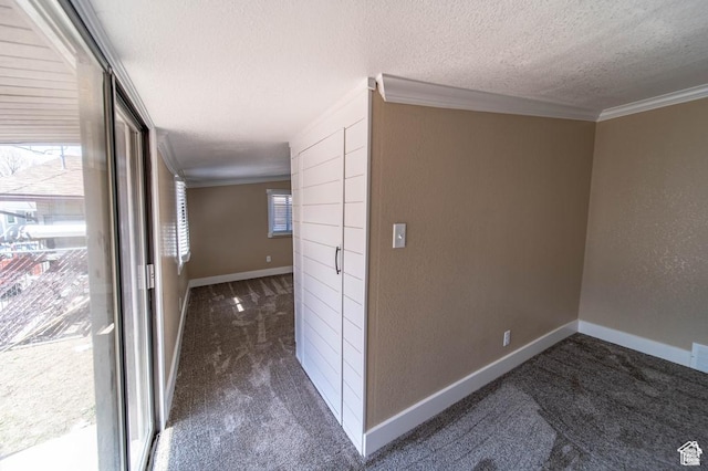 hall with crown molding, dark carpet, and a textured ceiling