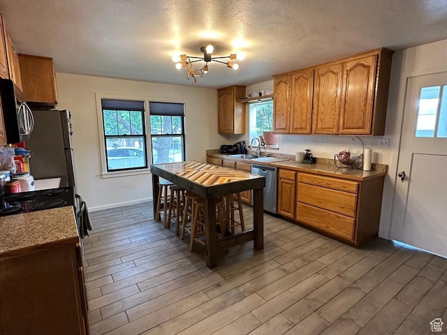 97 N 100 E, Marysvale, UT 84750 - kitchen with appliances with stainless steel finishes, light wood-type flooring, a textured ceiling, and sink