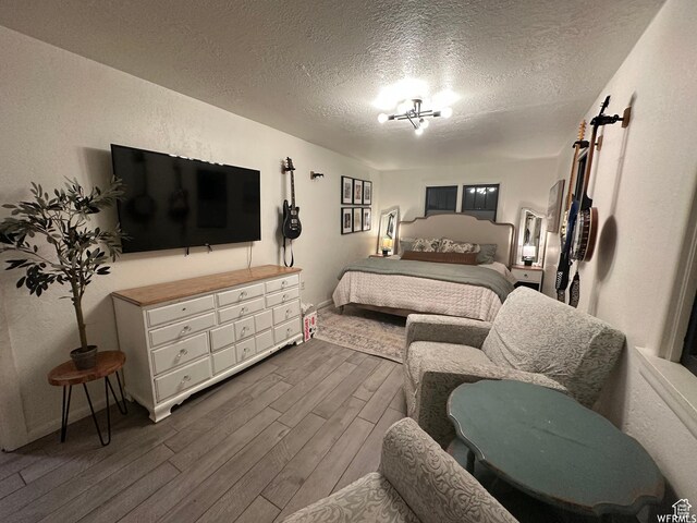 97 N 100 E, Marysvale, UT 84750 - bedroom featuring a textured ceiling, dark hardwood / wood-style floors, and a notable chandelier