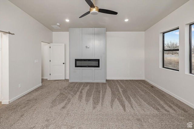unfurnished living room featuring carpet flooring and ceiling fan
