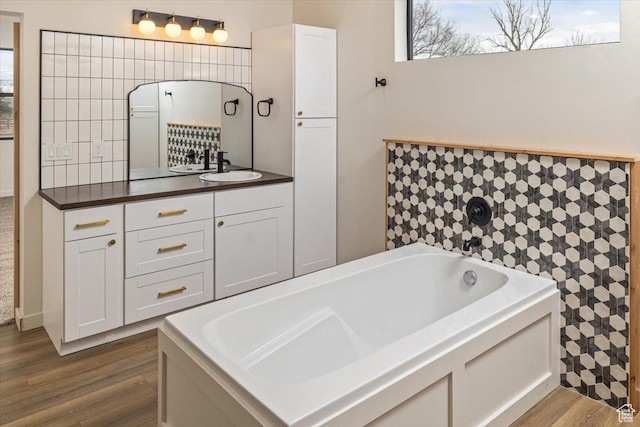 bathroom with a tub, vanity, and hardwood / wood-style flooring