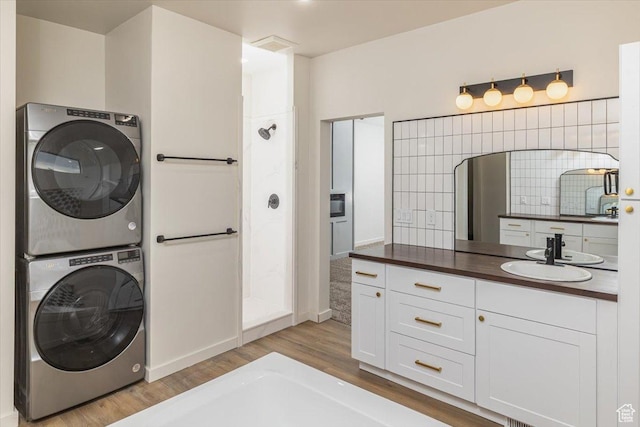 interior space featuring sink, stacked washer and clothes dryer, and light hardwood / wood-style flooring