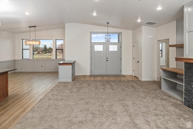 entrance foyer featuring lofted ceiling and light wood-type flooring