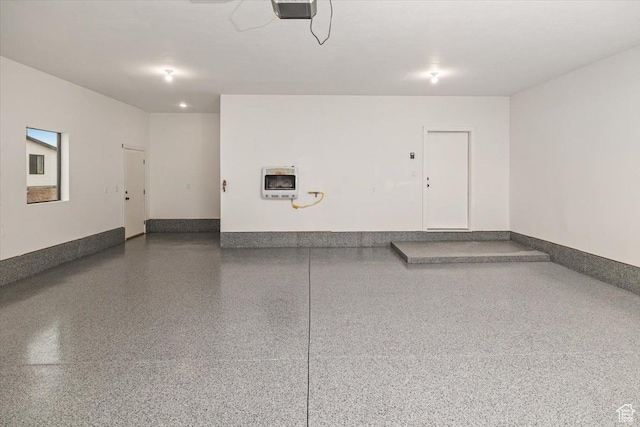 garage featuring heating unit and a garage door opener