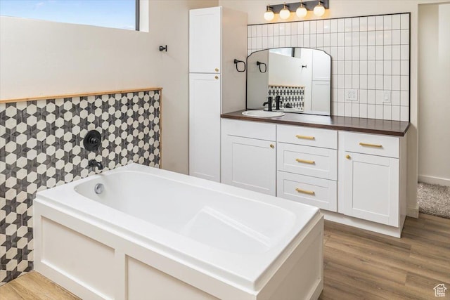 bathroom featuring hardwood / wood-style floors, vanity, and a bath