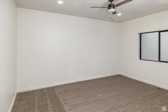 carpeted spare room with ceiling fan