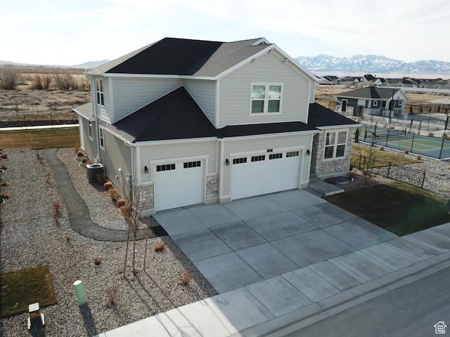 633 W Junegrass Ln, Stansbury Park, UT 84074 - view of front facade featuring a mountain view, a garage, and cooling unit