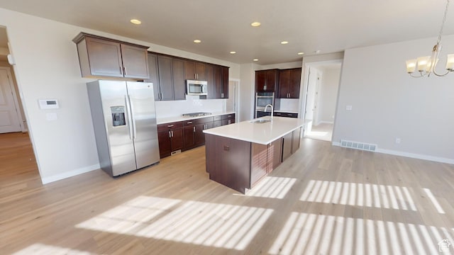 633 W Junegrass Ln, Stansbury Park, UT 84074 - kitchen featuring hanging light fixtures, stainless steel appliances, a notable chandelier, an island with sink, and dark brown cabinets