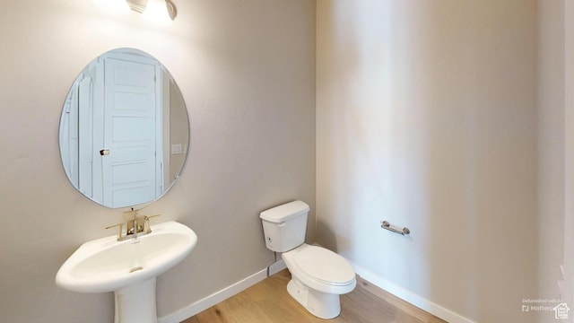 633 W Junegrass Ln, Stansbury Park, UT 84074 - bathroom featuring hardwood / wood-style flooring, toilet, and sink