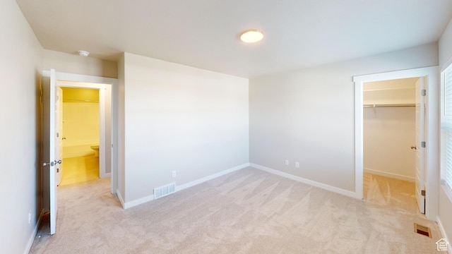 633 W Junegrass Ln, Stansbury Park, UT 84074 - unfurnished bedroom featuring a spacious closet, light carpet, and a closet
