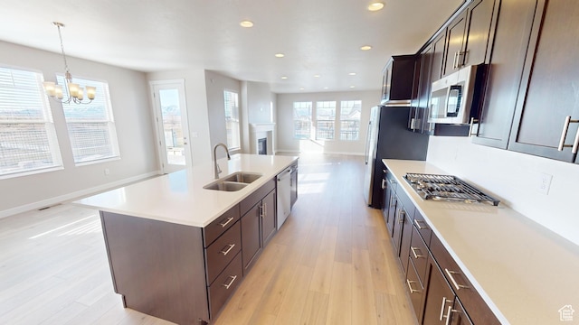 633 W Junegrass Ln, Stansbury Park, UT 84074 - kitchen with sink, hanging light fixtures, stainless steel appliances, a notable chandelier, and an island with sink