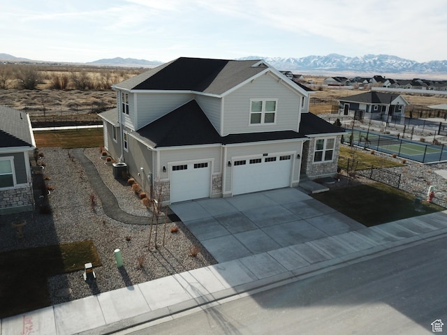 633 W Junegrass Ln, Stansbury Park, UT 84074 - view of front of house featuring a mountain view, central AC, and a garage