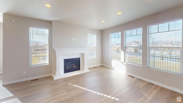 633 W Junegrass Ln, Stansbury Park, UT 84074 - unfurnished living room with plenty of natural light and light hardwood / wood-style floors