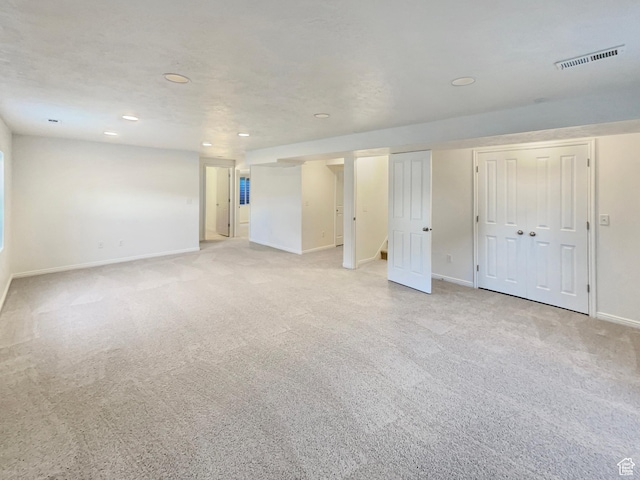 basement featuring light colored carpet