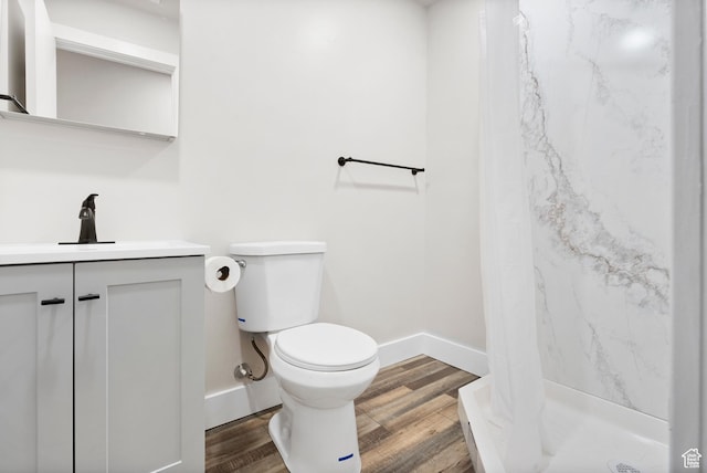 bathroom featuring wood-type flooring, vanity, toilet, and walk in shower