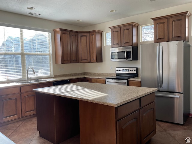 1036 N Darcy Dr W, North Salt Lake, UT 84054 - kitchen with plenty of natural light, a center island, sink, and appliances with stainless steel finishes
