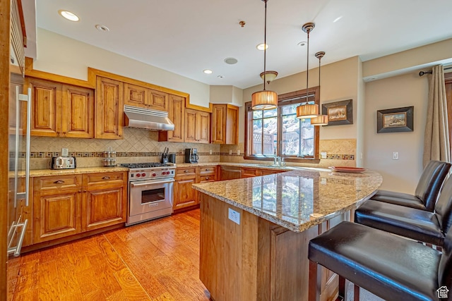 4129 Fairway Ln Unit A-3, Park City, UT 84098 - kitchen featuring light stone countertops, a kitchen breakfast bar, decorative backsplash, stainless steel appliances, and hanging light fixtures