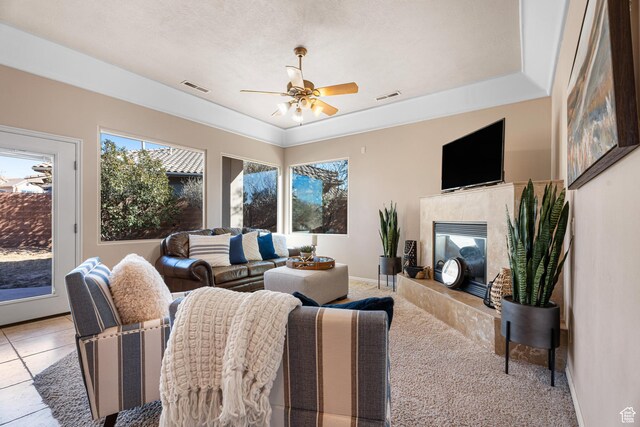 2371 E 2830 S, St George, UT 84790 - tiled living room featuring a tray ceiling, ceiling fan, and a high end fireplace