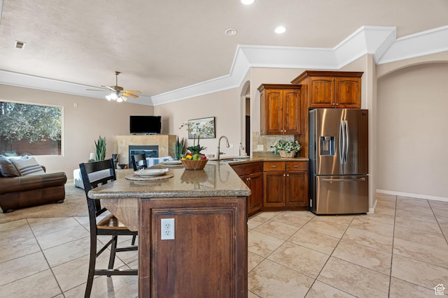 2371 E 2830 S, St George, UT 84790 - kitchen with a tile fireplace, sink, stainless steel refrigerator with ice dispenser, ceiling fan, and kitchen peninsula
