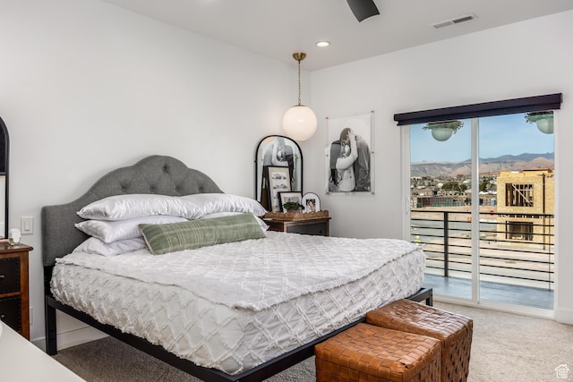 bedroom featuring carpet flooring, a mountain view, and access to outside