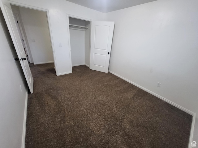 3318 E Quarter Mile Dr, Eagle Mountain, UT 84005 - unfurnished bedroom featuring a closet, dark carpet, and baseboards