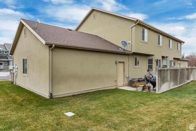 3318 E Quarter Mile Dr, Eagle Mountain, UT 84005 - back of property featuring roof with shingles, a patio, a lawn, and stucco siding