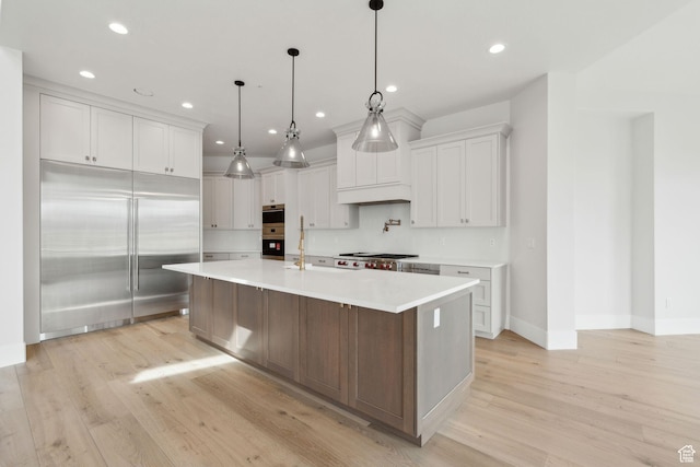 3097 E Corral Peak Cir Unit 145, Heber City, UT 84032 - kitchen with white cabinetry, light countertops, light wood finished floors, and stainless steel appliances