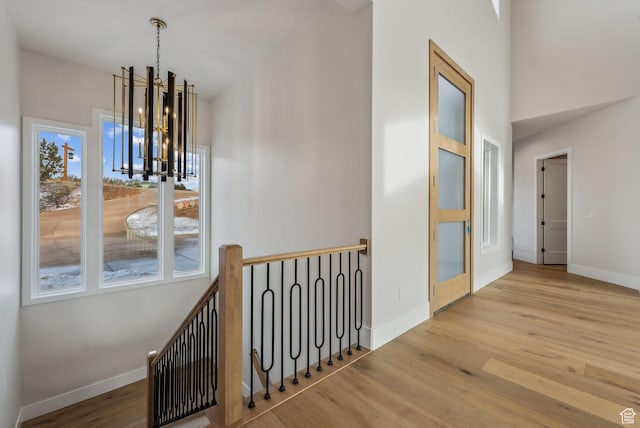 3097 E Corral Peak Cir Unit 145, Heber City, UT 84032 - hallway with baseboards, a notable chandelier, and wood finished floors