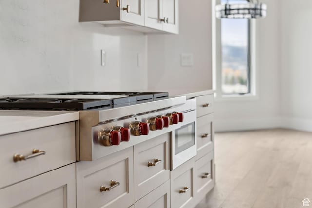 3097 E Corral Peak Cir Unit 145, Heber City, UT 84032 - kitchen with stainless steel gas cooktop, light wood-style floors, light countertops, and white cabinetry