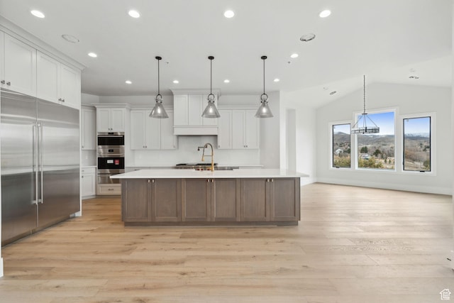 3097 E Corral Peak Cir Unit 145, Heber City, UT 84032 - kitchen featuring light wood-type flooring, white cabinetry, appliances with stainless steel finishes, a sink, and light countertops