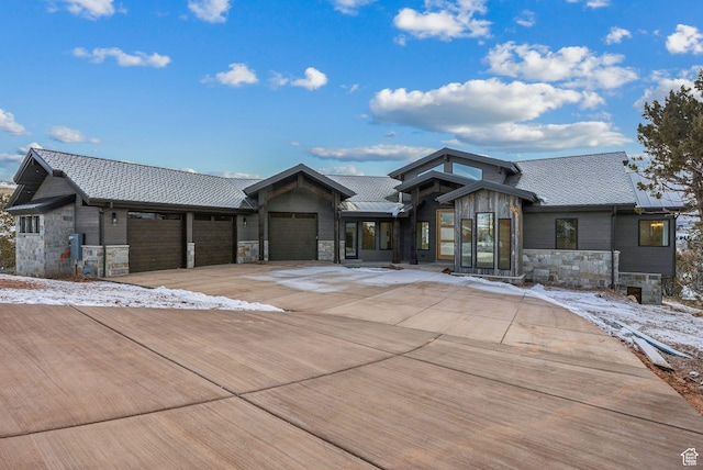 view of front of house with concrete driveway, stone siding, and an attached garage