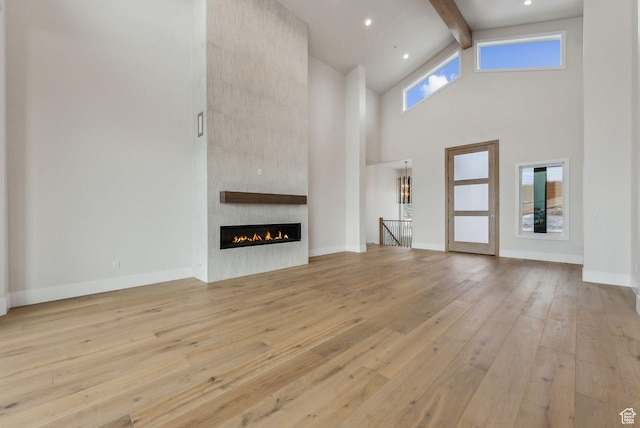 3097 E Corral Peak Cir Unit 145, Heber City, UT 84032 - unfurnished living room with hardwood / wood-style floors, high vaulted ceiling, a fireplace, and beam ceiling