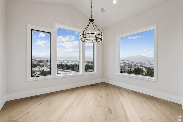 3097 E Corral Peak Cir Unit 145, Heber City, UT 84032 - unfurnished dining area with a chandelier, light wood-type flooring, baseboards, and lofted ceiling